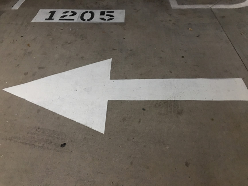 Directional Arrow White In Parking Lot