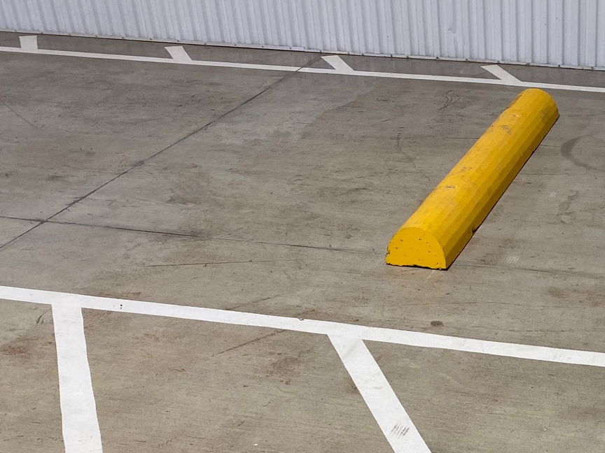 Wheel Stop Painted Yellow In Parking Lot