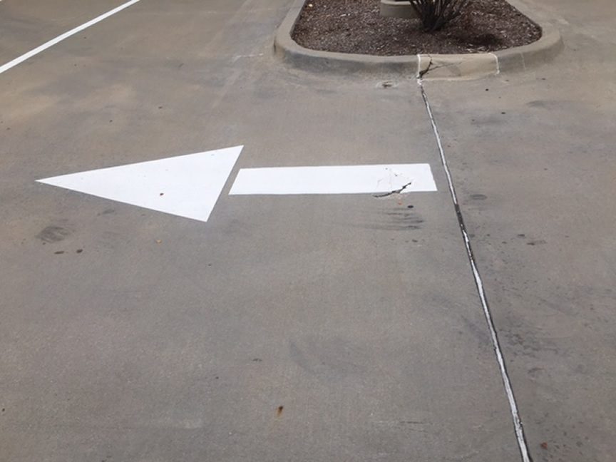 White Painted Directional Arrow in Parking Lot